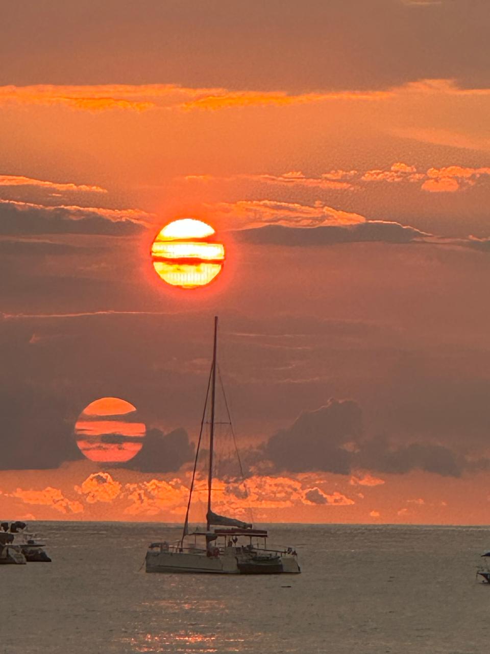 Blood-orange sunset over sailboats in Tamarindo bay